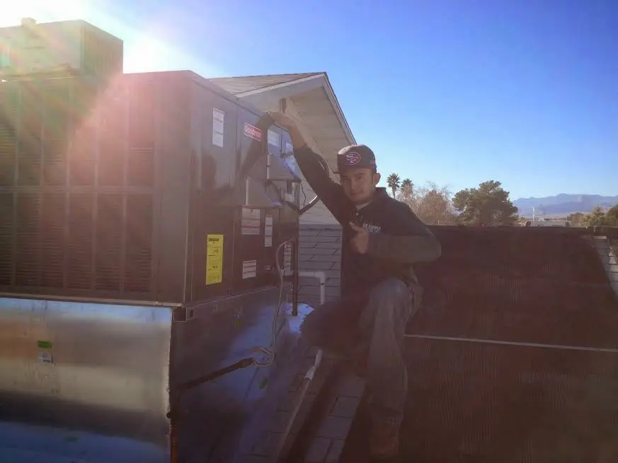 HVAC technician performing Boiler Repair on a rooftop unit in Collegeville